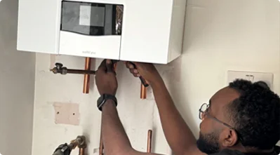 Hey Boiler engineer carrying out a boiler service in a London home